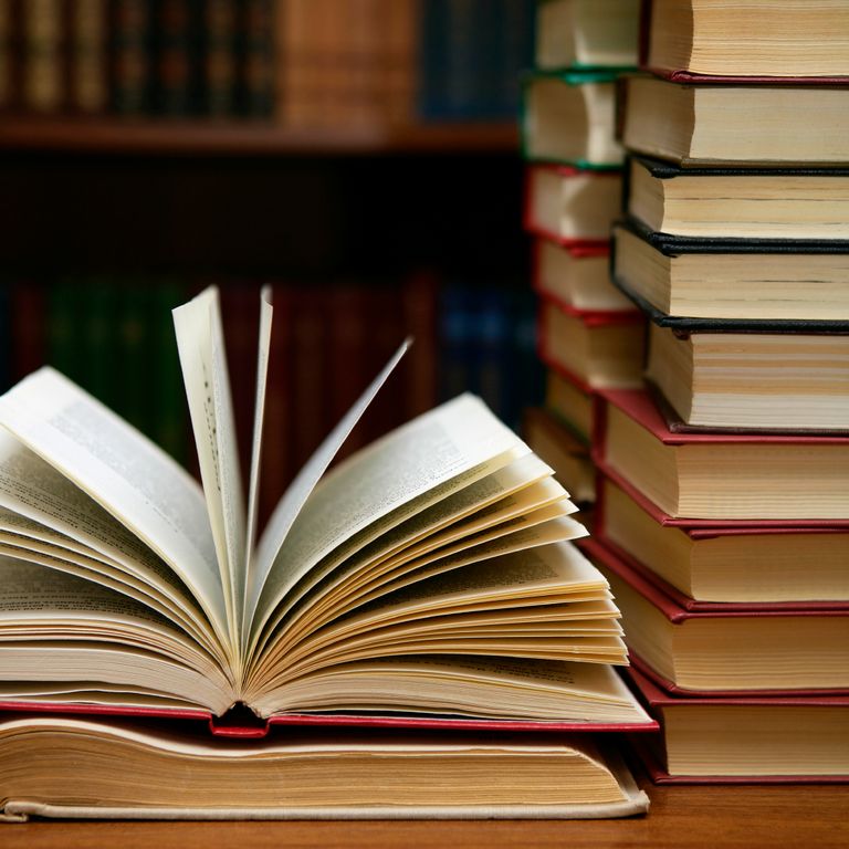 Photo of an open book (left) and stacks of books (right)